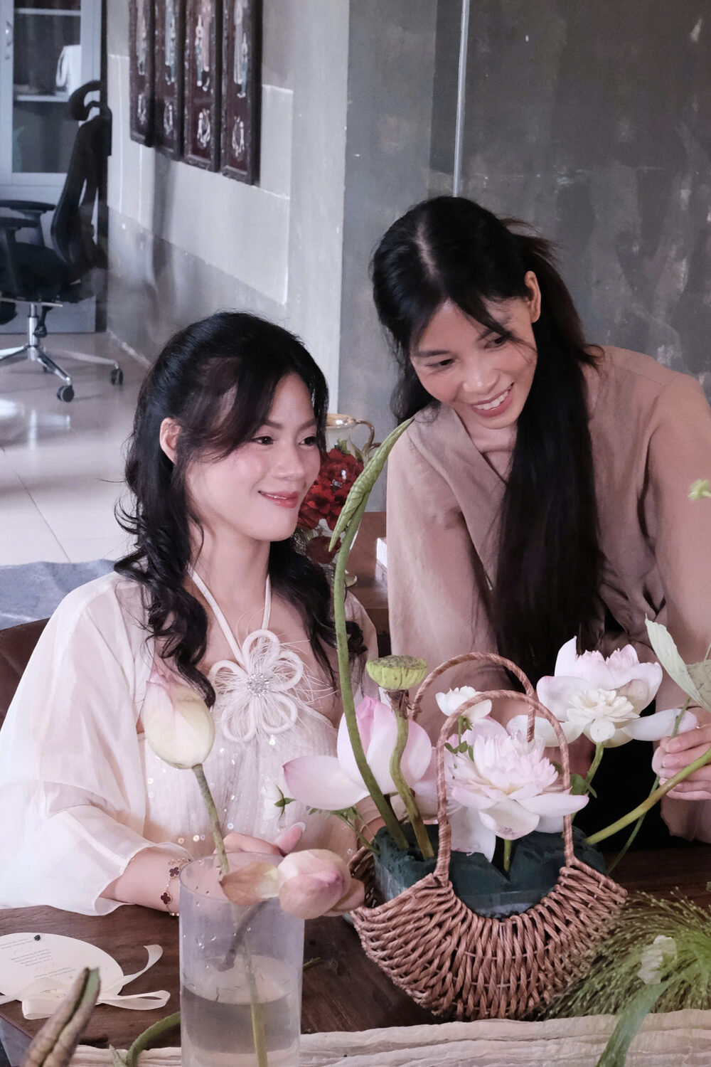 Two students smiling over a lotus basket